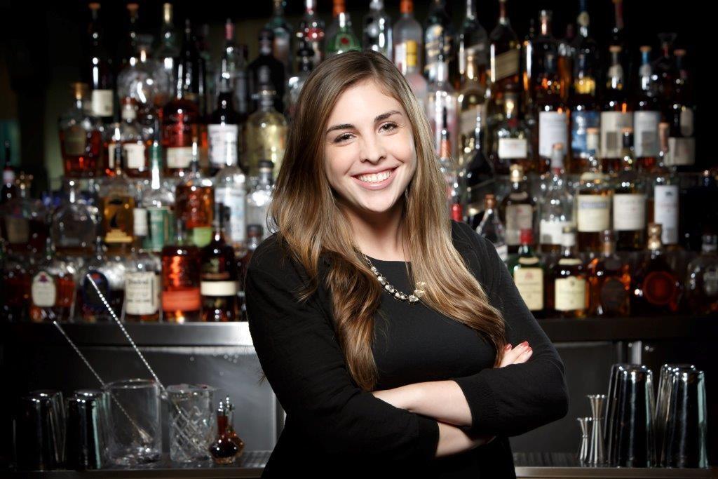 Image of Alicia Garcia standing in front of a bar.